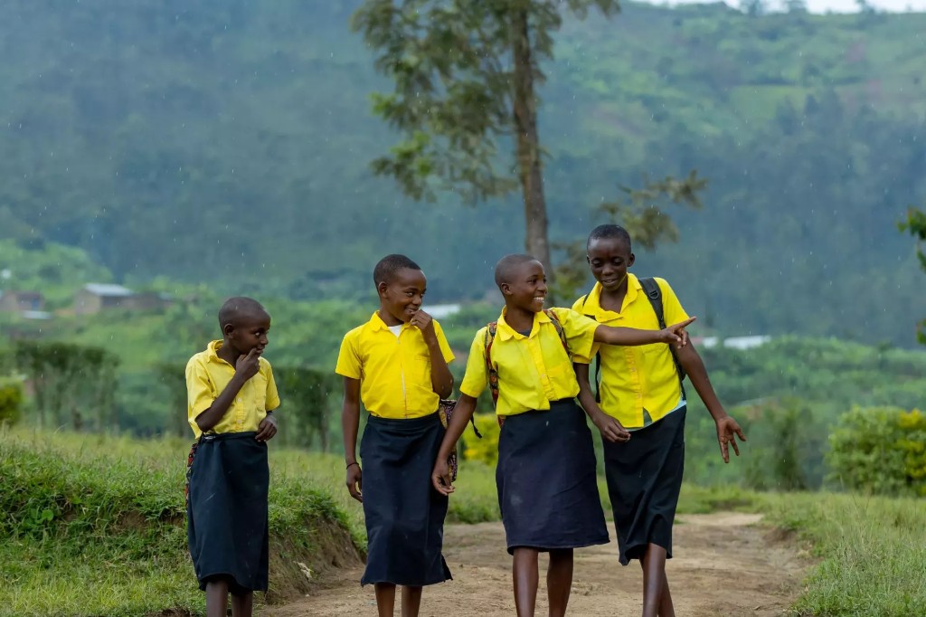 Rwandan students in school uniforms studying outdoors